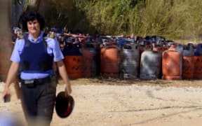 A policewoman in front of dozens of gas bottles in Alcanar during a search linked to the Barcelona and Cambrils attacks.