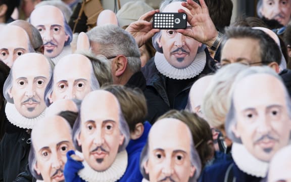 People wearing William Shakespeare masks line the street in Stratford-upon-Avon during a parade to mark 400 years since the bard's death.