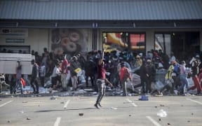 A man gestures as rioters loot the Jabulani Mall in the Soweto district of Johannesburg on July 12, 2021.