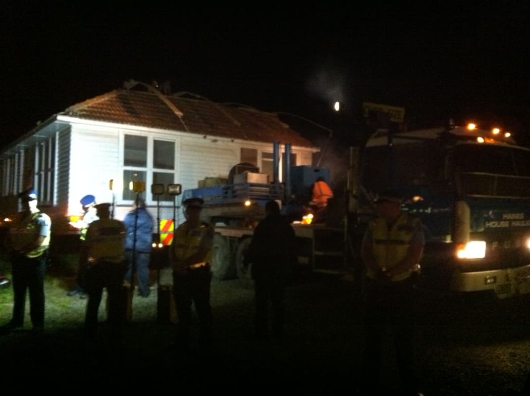 The house being moved under police guard.