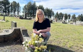 Central Otago District Council cadet Jocelyn Ryan laying flowers on the only unknown grave at Ranfurly Cemetery,