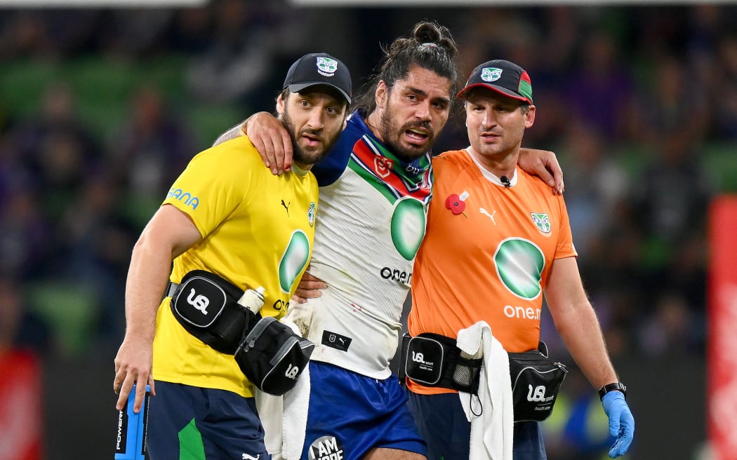 Tohu Harris of the Warriors is helped from the field with an injury.