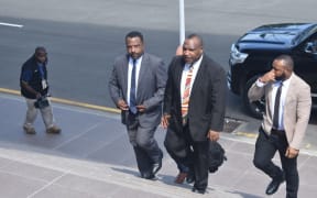 James Marape (centre in black suit) walks back to parliament after being sworn in as prime minister of Papua New Guinea, 30 May 2019.