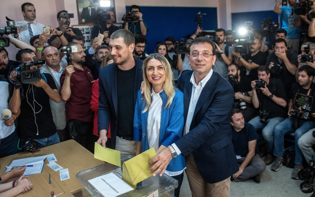 Istanbul mayoral candidate of the main opposition Republican People's Party (CHP) Ekrem Imamoglu, right, casts his vote with wife Dilek Imamoglu, centre, and son Semih Imamoglu, left.