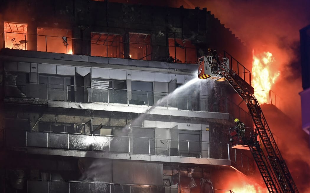 Firefighters battle a huge fire raging through a multistorey residential block in Valencia on February 22, 2024. (Photo by Jose Jordan / AFP)