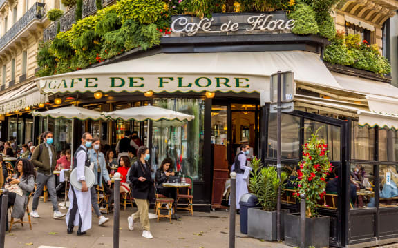 Waiters wear masks at a famous Parisian cafe on 19 May, 2021, a day after lockdown due to Covid-19.