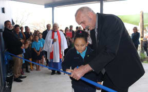 Seven-year-old Lyreena Heta helps Far North Mayor John Carter cut the ribbon for Kerikeri Primary Schools new classroom block.