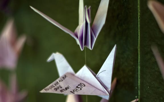 Origami birds hang with prayers and well-wishes for the missing passengers at a mall in Kuala Lumpur.