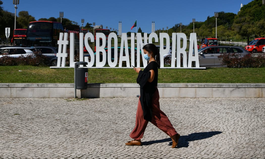 A woman wearing protective mask walks near the Eduardo VII square, Lisbon, Portugal. 07 October 2021.