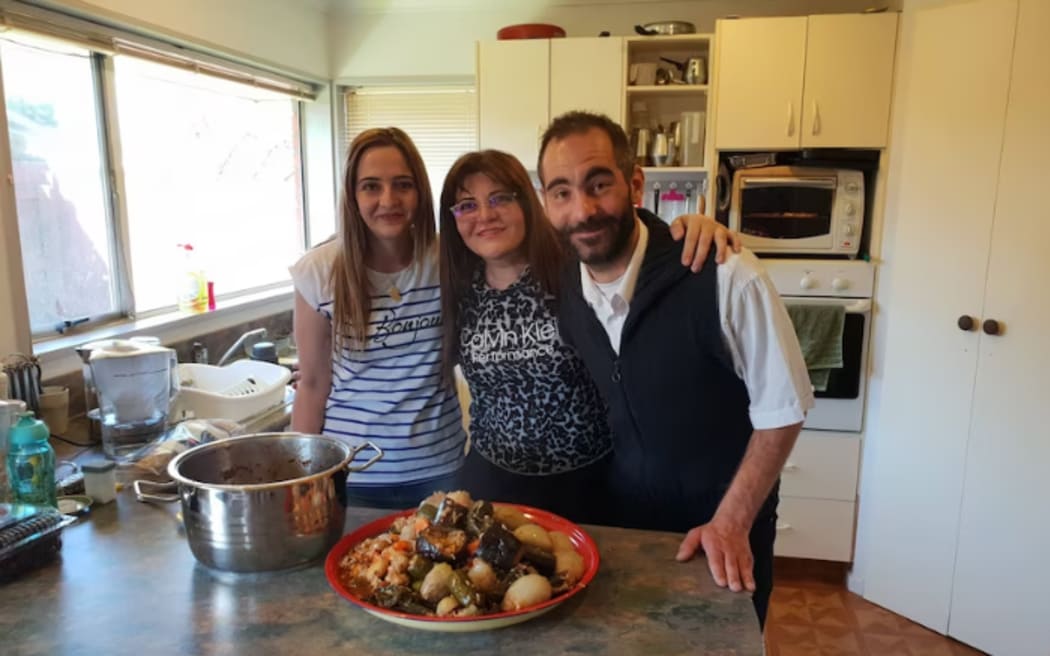 Aya al-Umari with her brother Hussein and their mother Janna Ezat (centre) in their kitchen, celebrating what would be Hussein's last birthday, in January 2019.