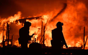 Firefighters douse flames as a home burns in the Napa wine region.