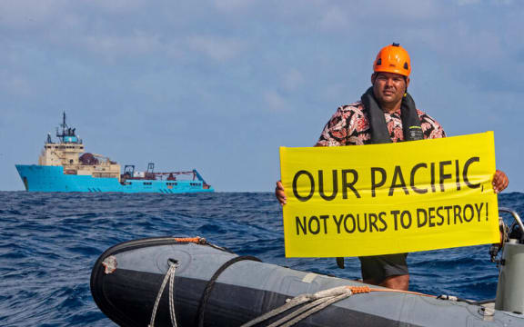 Victor Pickering, a Greenpeace activist from Fiji, in front of the Maersk Launcher, a ship chartered by DeepGreen.