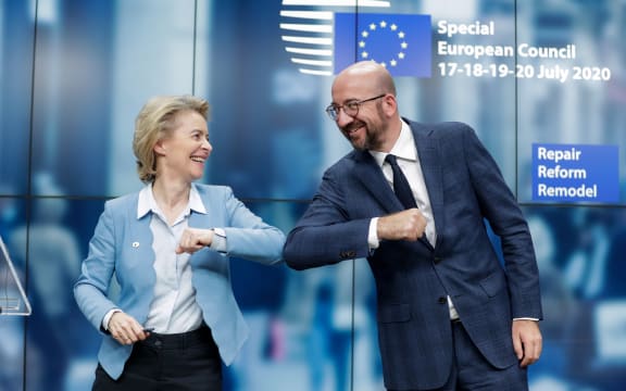 European Commission President Ursula Von Der Leyen (L) and European Council President Charles Michel (R) bump elbows at the end of the news conference following a four days European summit at the European Council in Brussels, Belgium