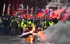 Protesters wearing yellow vests set up a barricade during a demonstration against rising costs of living they blame on high taxes in France.