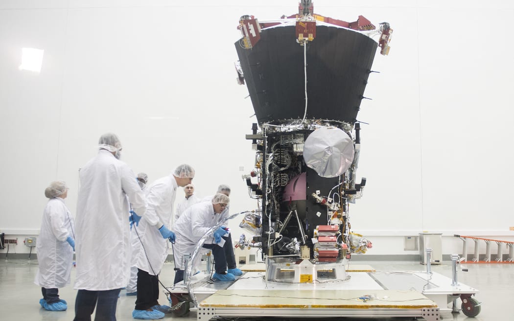 Engineers examine the Parker Solar Probe during a media preview at NASA Goddard Space Flight Center in Greenbelt, Maryland, on March 28, 2018. The spacecraft is undergoing final testing before it ships to NASA’s Kennedy Space Flight Center in Florida for a scheduled July 31 launch when it will travel on a daring trek, traveling closer to the Sun than any spacecraft in history. (Photo by JIM WATSON / AFP)