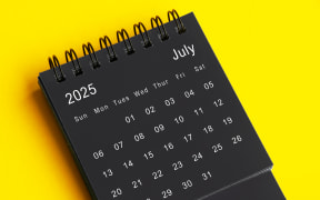 July 2025 black and white desk calendar on yellow cover background. Calendar concept.