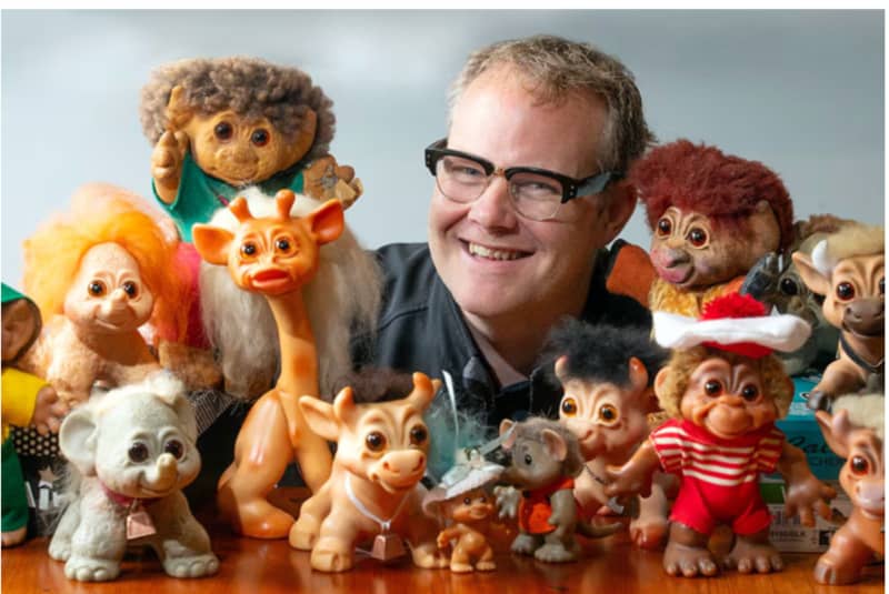Damian Sutton is surrounded by his Trolls collection.