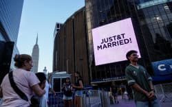 A screen displaying a message referencing Taylor Swift and  Travis Kelce outside Madison Square Garden - the venue for their reported wedding celebrations.