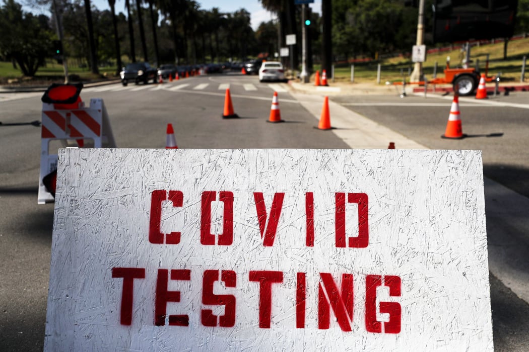 People in cars (TOP L) are lined up to be tested for COVID-19 as they make their way to a parking lot at Dodger Stadium amid the coronavirus pandemic on June 26, 2020 in Los Angeles, California.