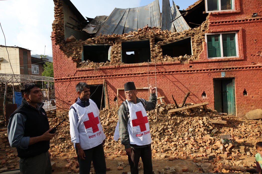Members of the Nepal Red Cross look at a damaged building in Kathmandu.