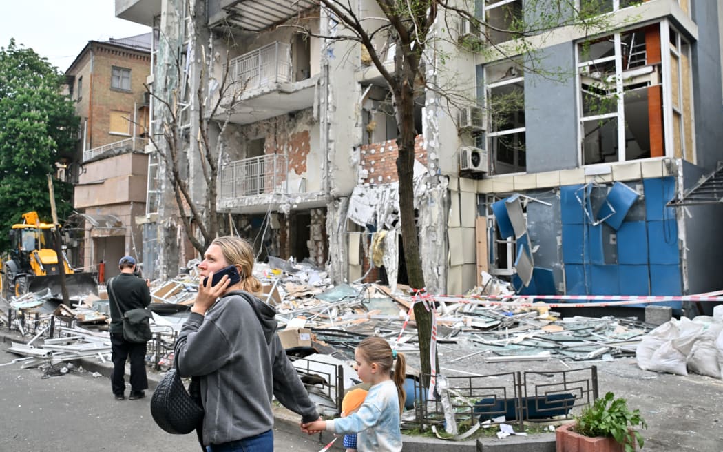 People walk past a multistory residential building  damaged following  a drone strike in Kyiv on May 25, 2025, amid Russian invasion in Ukraine. Russia launched a record number of drones against Ukraine and killed 12 people across the country, officials said on May 25, even as Kyiv and Moscow completed their biggest prisoner exchange since the start of the war. (Photo by Sergei SUPINSKY / AFP)