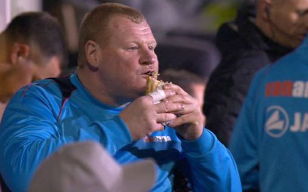 Sutton reserve goalkeeper Wayne Shaw tucks into a pie.
