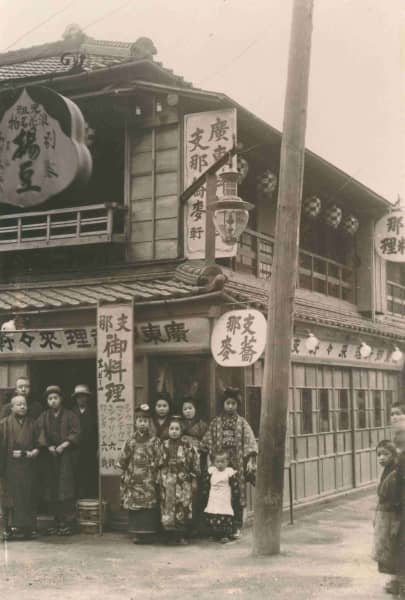 Kan'ichi Ozaki outside his ramen shop, Rai-Rai Ken, in Asakusa, Japan before 1914, with his family.