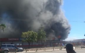 Shops have been set on fire or looted in parts of Papua New Guinea's capital Port Moresby as people make the most of a police and military strike