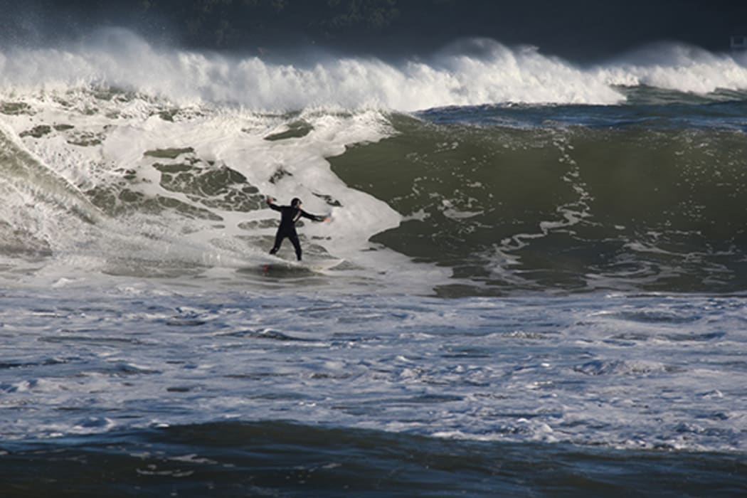 A surfer at Lyall Bay after a storm surge on 14 June 2015.