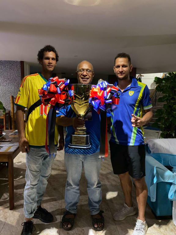 Alwin Komolong (R) with his brother Felix and their dad holding the NSL Cup.