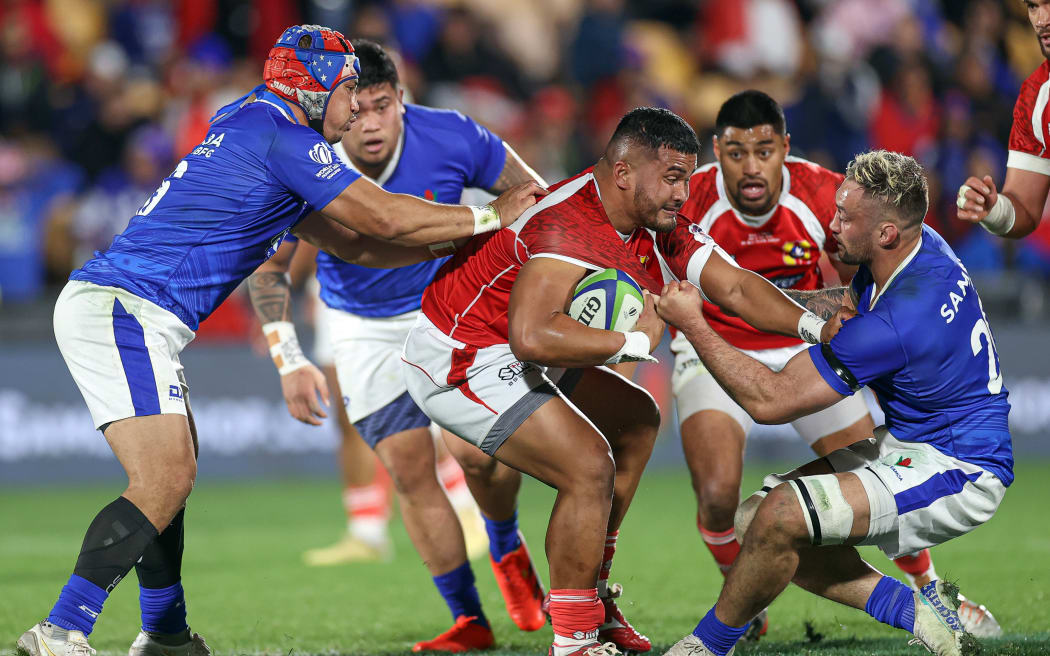 Tonga's Siua Maile is tackled during the first leg of their World Cup qualifying playoff against Samoa.