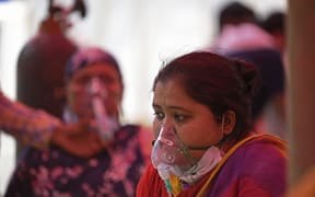 Patients breathe with the help of oxygen provided by a Gurdwara, a place of worship for Sikhs, under a tent installed along the roadside amid the Covid-19 pandemic in Ghaziabad on 26 April 2021.