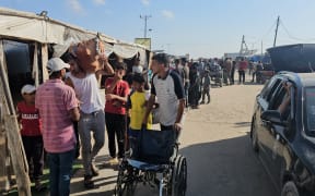 Displaced Palestinians receive food packages from a US-backed foundation pledging to distribute humanitarian aid in western Rafah in the southern Gaza Strip.