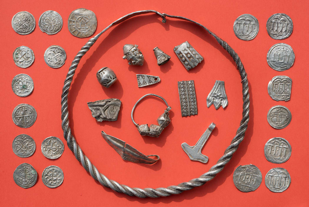 Some of the silver treasures from Schaprode, including a coiled ring, silver beads, cut-up silver jewellery, Thor's hammer amulet, and Danish and Ottonian coins.