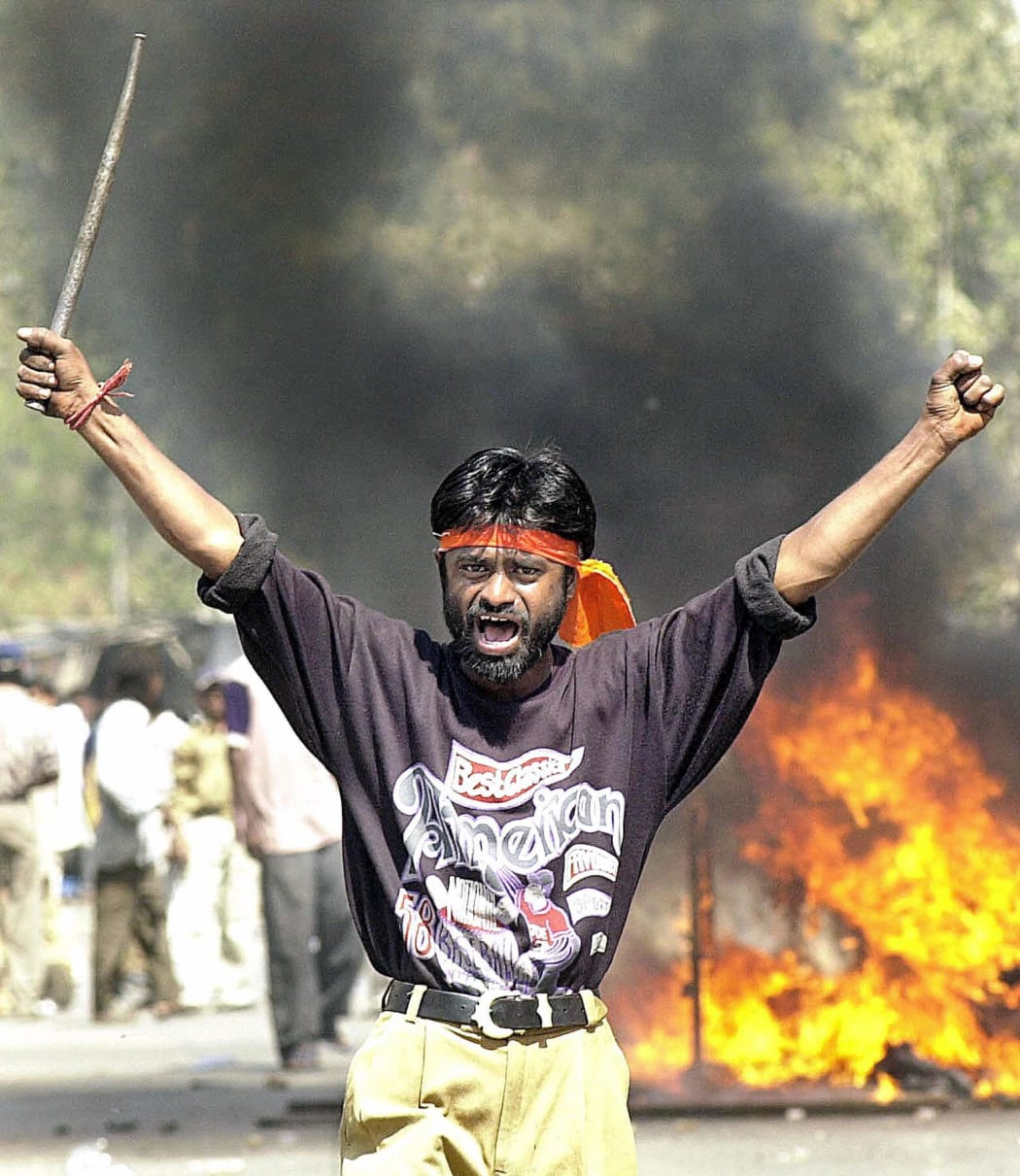 This file photograph taken in 2002 shows an Indian Bajranj Dal activist armed with a iron stick shouting slogans against Muslims.