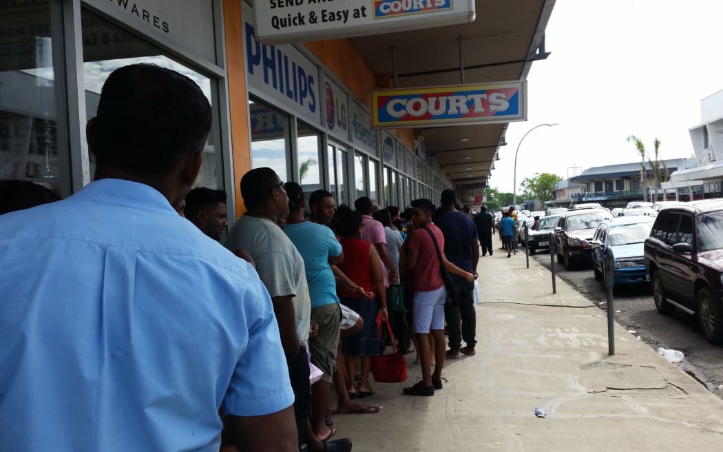 People queue in Lautoka for their Fiji National Provident Fund cheques as part of cyclone relief