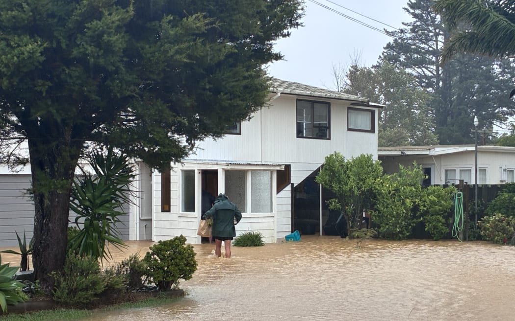 Whitianga residents carry in supplies and say they are going to stay rather than evacuate despite the water being knee height