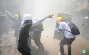 Protesters react after tear gas is fired by police during a demonstration against the military coup in Yangon on March 7.