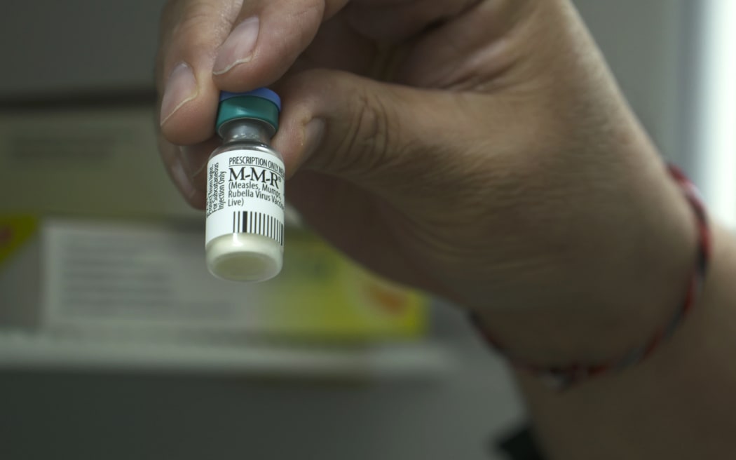 Dr Richard Hulme holding Measles Vaccine
