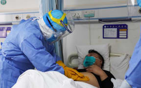 A medical staff member checking a patient infected by the novel coronavirus in an isolation ward at a hospital in Zouping in China's eastern Shandong province.