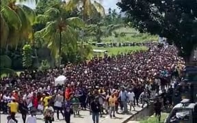 Thousands of Papuans carrying the coffin of Lukas Enembeto his final resting place.
