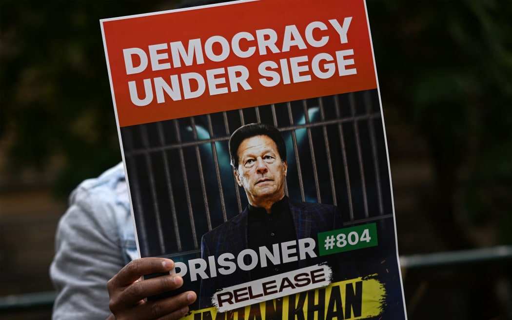 A supporter of Pakistan Tehreek-e-Insaf (PTI) party and jailed former prime minister Imran Khan holds a placard during a protest rally in Sydney on August 4, 2024, demanding Khan's release from the jail. (Photo by Saeed KHAN / AFP)