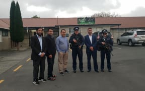 Community members from the Rasol-O-Allah Islamic Centre with armed police.