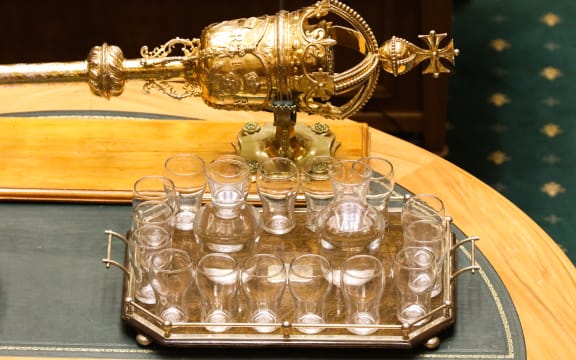 Parliament's Mace sits on The Table next to a tray of water for MPs