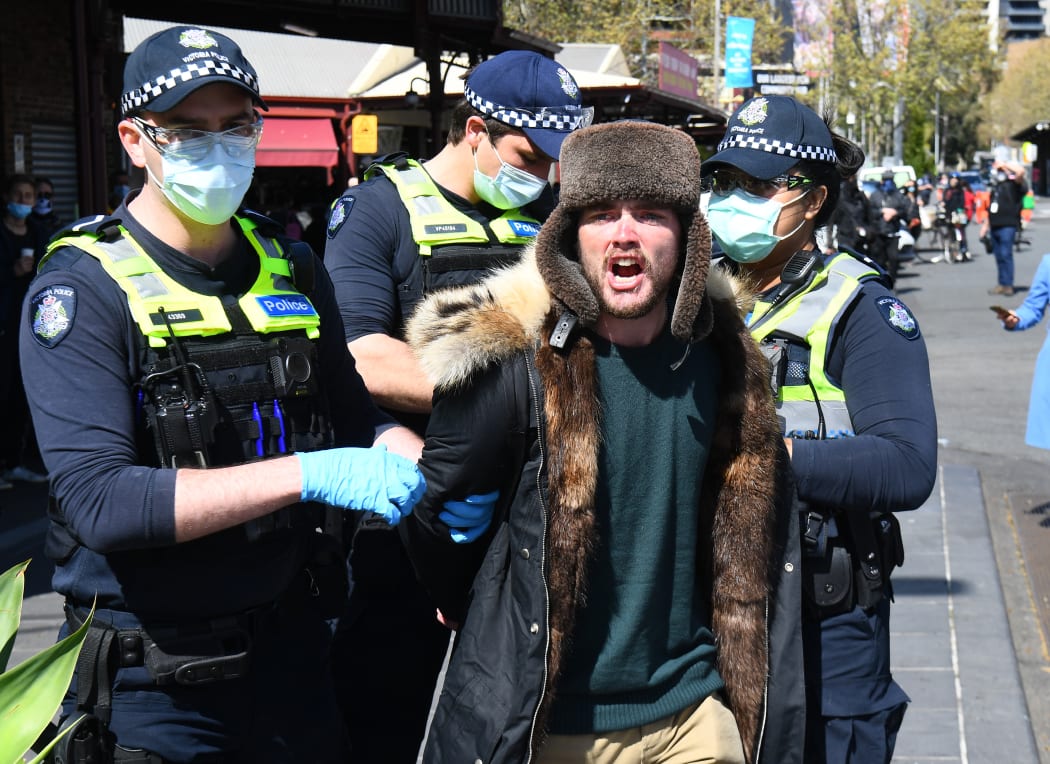 Police detain an anti-lockdown protester