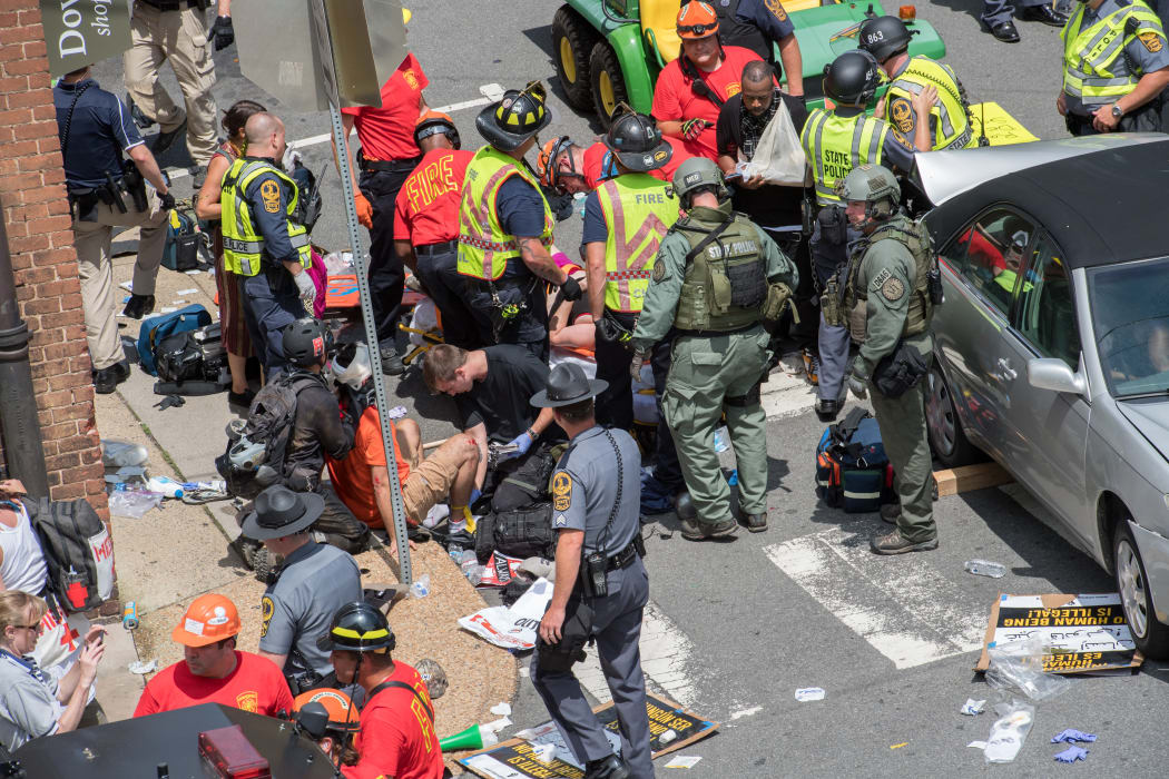 Emergency services assist victims after a car ploughed into them, killing one woman and injuring 19 others