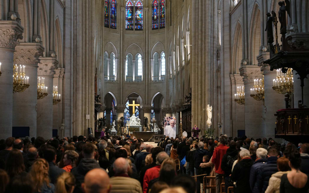 People attend a mass in Notre-Dame Cathedral to honour Pope Francis following his death, in Paris on April 21, 2025. Pope Francis died on April 21, 2025 aged 88, a day after making a much hoped-for appearance at Saint Peter's Square on Easter Sunday, the Vatican said in a statement. (Photo by Dimitar DILKOFF / AFP)