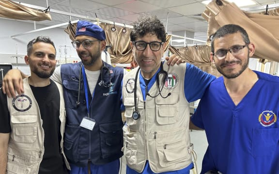 Dr. Ammar Ghanem, an ICU specialist from Detroit volunteering with the Syrian American Medical Society at one of Gaza's last functioning hospitals, second from right, poses on May 7, 2024, in Khan Younis, Gaza, with a Palestinian doctor and two other American doctors volunteering at the European General Hospital where they have been since early May. A group of 35 foreign doctors on a volunteer mission to help at the hospital, including 22 Americans, have been trapped in Gaza by Israel’s seizure of the Rafah crossing into Egypt.