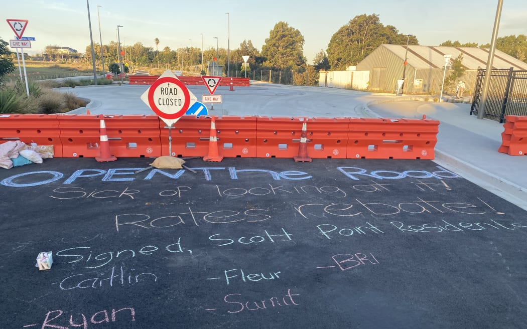 Residents left messages for Auckland Transport in chalk, calling on them to open the road to the public.