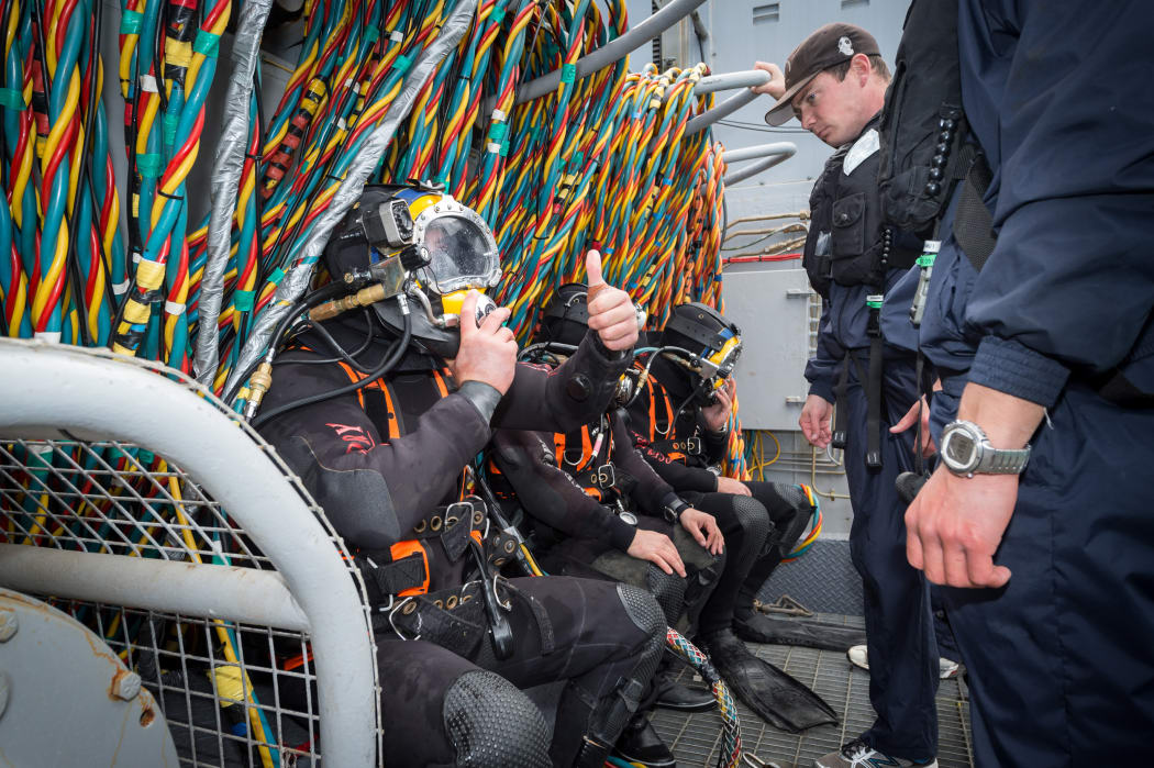 A navy diver gives the 'thumbs up' prior to diving from HMNZS Manawanui during a training session in Akaroa Harbour on 26 October 2015.